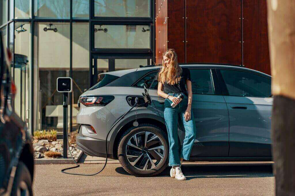 Une femme rechargeant sa voiture électrique