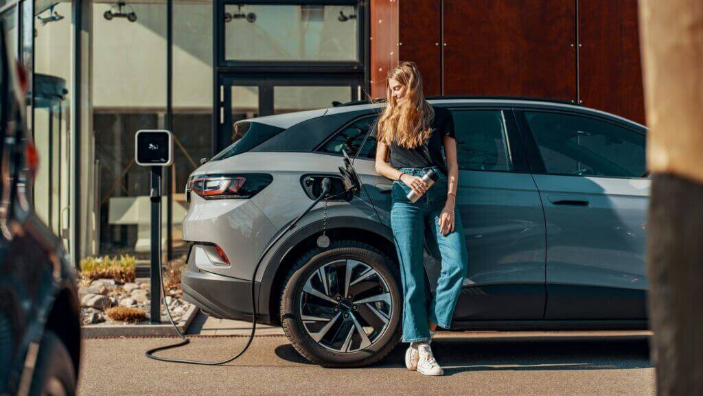Une femme rechargeant sa voiture électrique